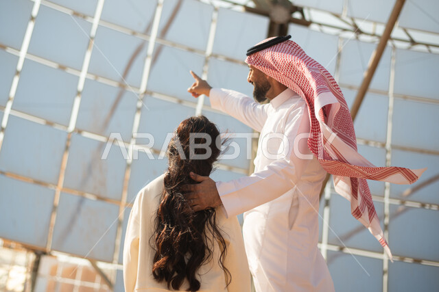صورة من الخلف لرجل عربي خليجي سعودي يتجول مع ابنته،  مستقبل السعودية، رؤية السعودية 2030، توليد الكهرباء عبر الطاقة الشمسية، الطاقة الطبيعية المتجددة، ستلايت و مشاريع السعودية المستقبلية،  مستقبل الطاقة
