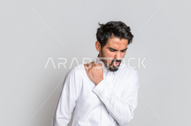 بورتريه لرجل عربي سعودي خليجي يرتدي الثوب السعودي, إيماءات وجه ويدين تدل على الشعور بالصداع, ألم بالرأس, الإحساس بالمرض, التعب والإرهاق, الحاجه للعلاج, طلب المساعده , خلفية بيضاء .