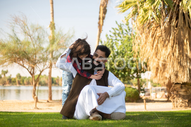 أب وابنه عربيان سعوديان خليجيان , الاستمتاع باللعب , قضاء أوقات ممتعة مع الابناء في احد الحدائق العامة في المملكة العربية السعودية، أماكن سياحية ترفيهية بالسعودية، فعاليات ترفيهية عائلية