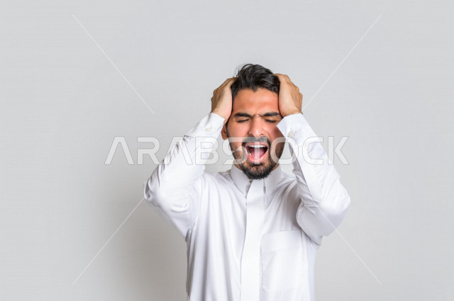 بورتريه لرجل عربي سعودي خليجي باللباس التقليدي , يقوم بإيماءات وجه ويدين تدل على الشعور بالصداع, ألم بالرأس, الإحساس بالمرض, التعب والإرهاق, الحاجه للعلاج, طلب المساعده , خلفية بيضاء .