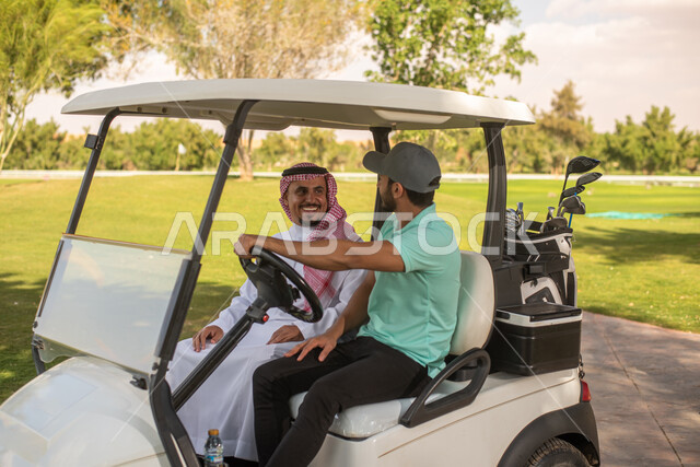 رجلان عربيان خليجيان سعوديان داخل سيارة جولف الكهربائية لنقل الركاب، لعبة الغولف ( الجولف ) ، أنشطة رياضية في السعودية، رياضات الألعاب الأولمبية الصيفية، أنشطة ترفيهية ممتعة، ملعب الجولف، نادي الجولف، عربة الجولف