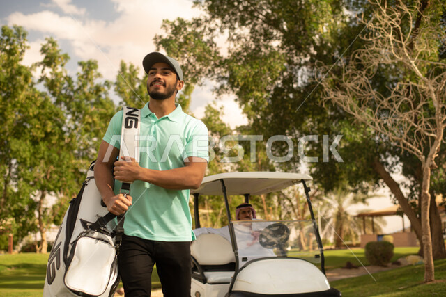 A close-up of two Saudi Arabian Gulf men on the golf course, an electric golf car for passenger transport, golf practice, large green spaces, sports activities, golf sport, the Summer Olympics, fun leisure activities, green nature background.