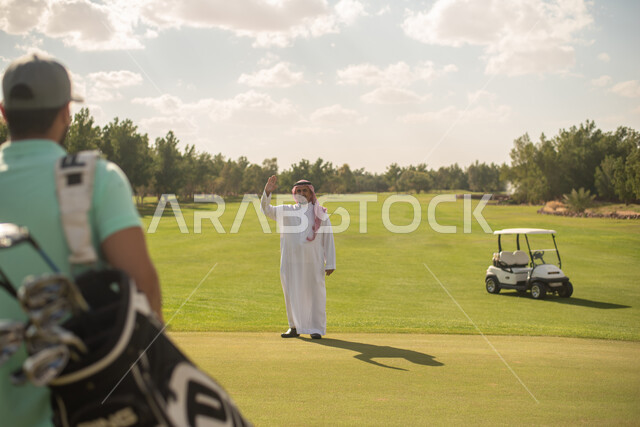 شابان عربيان خليجيان سعوديان في ملعب الجولف، ايماءات تدل على  التحية والسلام, ممارسة لعبة الغولف على مساحات واسعة خضراء، أنشطة رياضية في السعودية، لعبة الجولف، رياضات الألعاب الأولمبية الصيفية، أنشطة ترفيهية، ملعب الجولف
