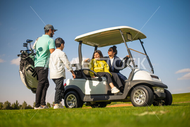 عائلة عربية خليجية سعودية في ملعب الجولف، أنشطة ترفيهية عائليه ممتعة,  سيارة جولف كهربائية لنقل الركاب، ايماءات تدل على السعادة، رياضة لعبة الجولف، الألعاب الأولمبية الصيفية، ممارسة لعبة الغولف على مساحات واسعة خضراء، ملعب الجولف