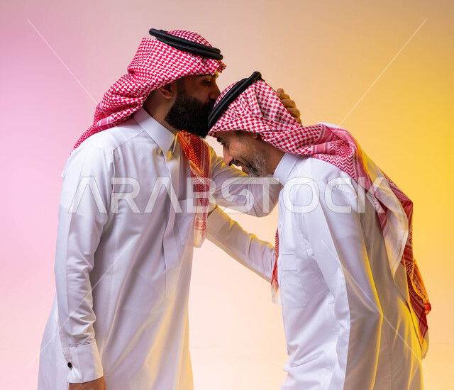 بورتريه لشاب عربي خليجي سعودي يقوم بتقبيل رأس والده ، بر الوالدين وصلة الارحام ،  ايماءات تدل على التقدير والاحترام ، ارتداء الزي التقليدي السعودي ،التجمعات الأسرية ،  التهنئه بالعيد السعيد ، خلفية ملونة
