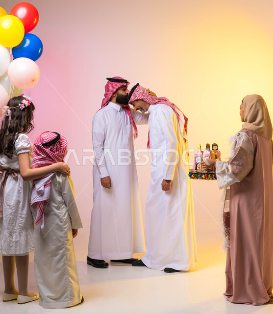 بورتريه لعائلة عربيه سعوديه خليجيه في غرفة الجلوس تحتفل بأيام العيد ، اجواء عائليه سعيده  ، رجل عربي خليجي سعودي يقوم بتقبيل رأس والده ، تقديم توزريعات وقرقيعان العيد  ، عيد سعيد ، الاحتفال بالأعياد الإسلامية  ، خلفية ملونة