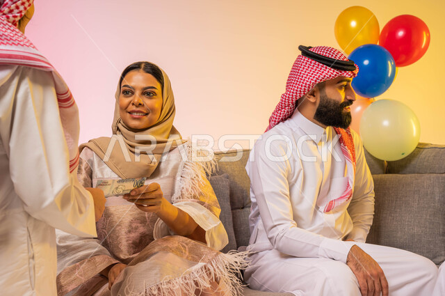 بورتريه لأمراه عربيه سعوديه خليجيه تقوم بتقديم العيديات للأطفال ، أجواء عائليه سعيده ، إيماءات تدل على الفرح والسرور بالعيد السعيد, الزيارات والتجمعات الاسريه, مناسبات واعياد اسلاميه ، خلفية ملونة