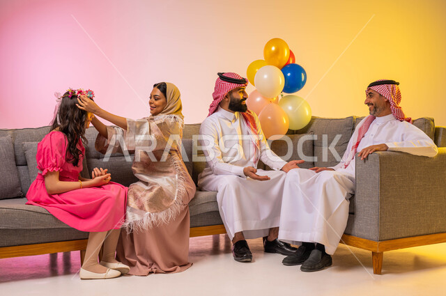 ايماءات وجه تدل على الفرح والسعادة ، أم عربيه سعوديه خليجيه تقوم بمساعدة ابنتها على التجمل والتهيؤ للعيد ،بورتريه لعائلة عربية خليجية سعودية تحتفل بقدوم العيد ، المناسبات والاعياد الاسلاميه ، خلفية ملونة