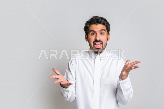 بورتريه لرجل عربي سعودي خليجي باللباس التقليدي , يقوم بإيماءات وجه ويدين تدل على الصراخ والتشاؤوم , التساؤل والإستغراب , الإستفهام عن شيء ما , خلفية بيضاء .