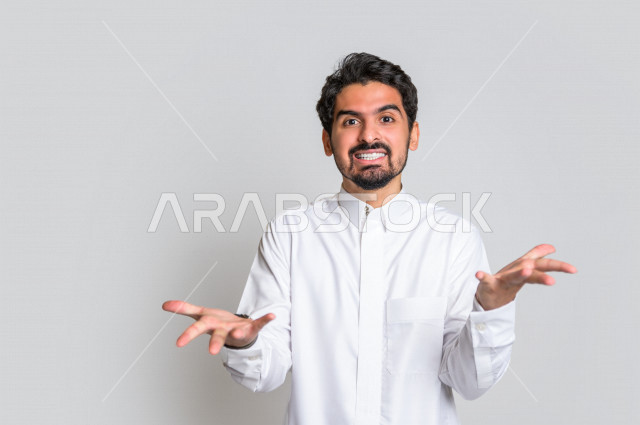 بورتريه لرجل عربي سعودي خليجي باللباس التقليدي , يقوم بإيماءات وجه ويدين تدل على الصراخ والتشاؤوم , التساؤل والإستغراب , الإستفهام عن شيء ما , خلفية بيضاء .