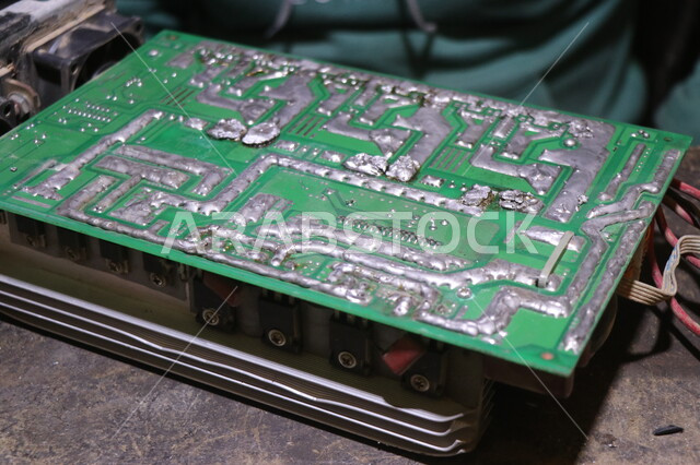 A close-up of a man repairing electronic parts, the concept of electronic engineering, microcircuits, electronic tools, maintenance and repair, manufacturing electronic devices, workers and factories