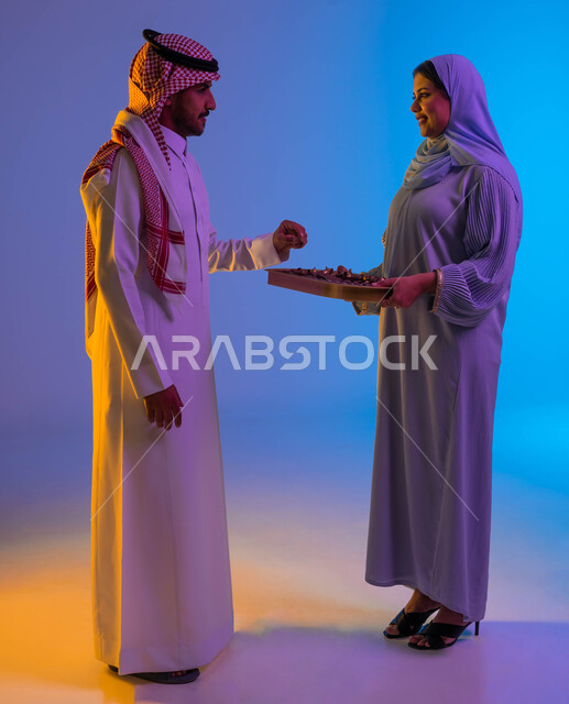 امرأة خليجية عربية سعودية تقدم حلوى العيد، اكرام الضيف، حسن الضيافة والإستقبال، الترحيب بالضيوف، ضيافة العيد، زيارات العيد، اجواء العائلة السعودية في العيد، عادات العيد في المجتمع السعودي، العيد بين الأهل، الاحتفال بالعيد السعيد، اعياد ومناسبات