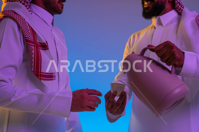 A close-up of a Saudi Arabian Gulf man pouring Arabic coffee, serving hot coffee to guests, honoring the guest, Saudi hospitality, good hospitality and reception, welcoming guests, Eid customs in Saudi society, Eid among the family, celebrating the happy 