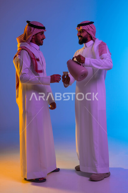 رجل عربي خليجي سعودي يقوم بصب القهوة العربية، تقديم القهوة الساخنة للضيوف، إكرام الضيف، الضيافة السعودية، حسن الضيافة والإستقبال، الترحيب بالضيوف، عادات العيد في المجتمع السعودي، العيد بين الأهل، الاحتفال بالعيد السعيد، اعياد ومناسبات