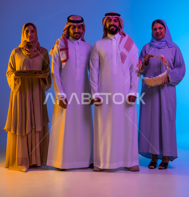 Portrait of a Saudi Arabian Gulf family, Eid sweets, Eid between family, joy and joy of Eid, Eid customs in the Saudi Gulf society, Eid visits, celebration of the happy Eid, sweets and Qirqe’an, holidays and occasions, colorful background
