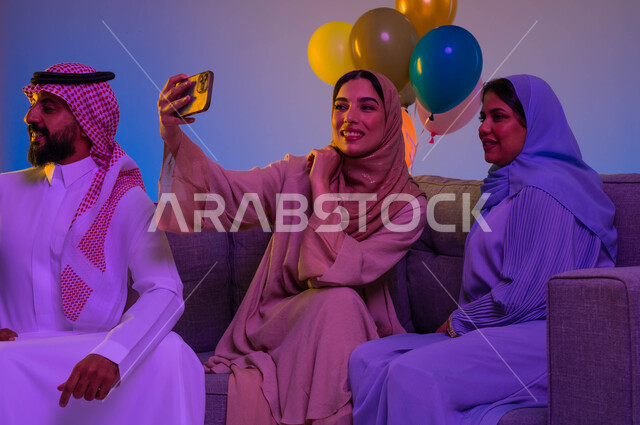 اجواء العائلة السعودية في العيد، امرأتان عربيتان خليجيتان سعوديتان، استخدام الهاتف المحمول، التقاط صور سيلفي تذكارية، الكاميرا الامامية، العيد بين الأهل، بهجة العيد، اللمة العائلية، عادات العيد في المجتمع السعودي، زيارات العيد، الاحتفال بالعيد السعيد