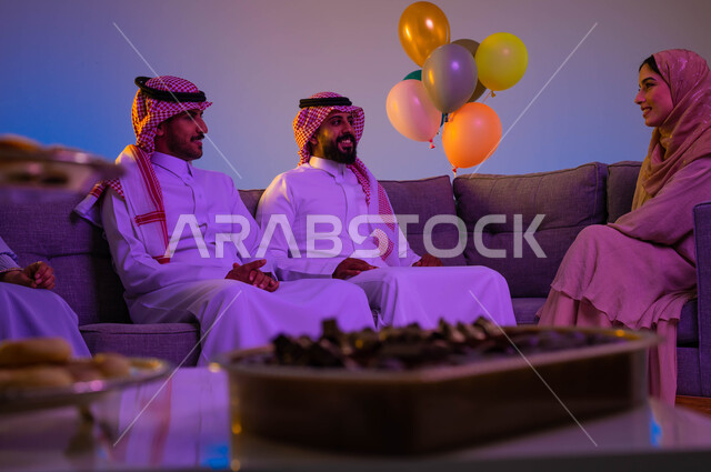 اجواء العائلة السعودية في العيد، عائلة عربية سعودية تجلس في غرفة المعيشة، كعك العيد، فوالة العيد، العيد بين الأهل، بهجه وفرحة العيد، اللمة العائلية، عادات العيد في المجتمع السعودي، زيارات العيد، الاحتفال بالعيد السعيد، الحلوى والقرقيعان، أعياد ومناسبات