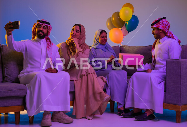 عائلة عربية خليجية سعودية، اجواء العائلة السعودية في العيد، استخدام الهاتف المحمول، التقاط صور تذكارية، صور سيلفي، تقديم هدايا العيد، العيد بين الاهل، بهجة وفرحة العيد، اللمة العائلية، العيد في المجتمع السعودي، زيارات العيد، الاحتفال بالعيد السعيد