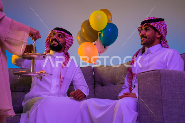 امرأه عربية خليجية سعودية تقوم بتقديم حلوى العيد للعائلة، اجواء العائلة السعودية في العيد، العيد بين الأهل، بهجة العيد، تجمع العائلة، اللمة العائلية في العيد، عادات العيد في المجتمع السعودي الخليجي، زيارات العيد، الاحتفال بالعيد السعيد، أعياد ومناسبات