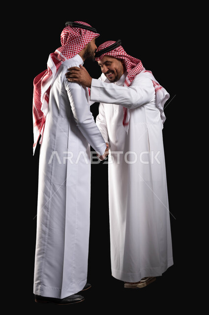 بورتريه مقرب لرجل عربي سعودي خليجي يرتدي الزي السعودي التقليدي يقوم بتقبيل رأس جده , أجواء عائليه سعيده, عيد مبارك, المناسبات والاعياد الاسلاميه, التجمعات الأسريه في العيد السعيد ، صورة الجسم بالطول الكامل ، خلفيه سوداء