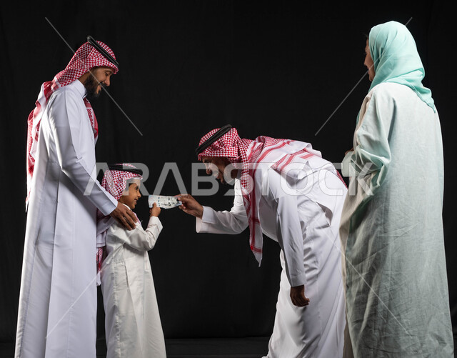 تقديم العيدية ، بورتريه لعائلة عربية خليجية سعودية ، الاحتفال بقدوم العيد ،أجواء العيد في السعودية  ، زيارات العيد ، إيماءات وجه تدل على الفرح والسعادة ، خلفية سوداء