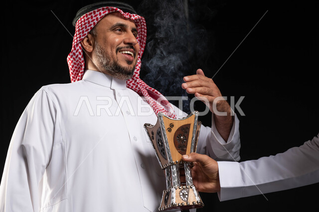 The use of agarwood, Eid visits, incense holder (bakhar), a portrait of a Saudi Arabian Gulf man wearing traditional Saudi clothing, the atmosphere of Eid in Saudi Arabia, a black background