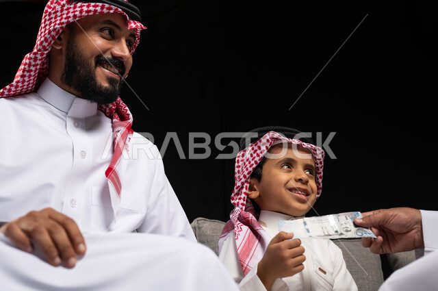 Family visits and gatherings, a portrait of a happy Saudi Arabian Gulf family, wearing traditional Saudi dress on holidays and special occasions, giving gifts to children, gestures indicating joy and pleasure in the happy holiday, Islamic occasions and ho
