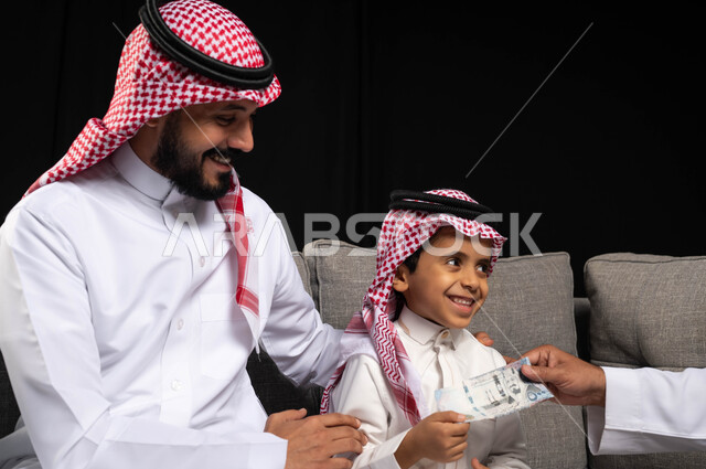 Portrait of a happy Saudi Arabian Gulf family, wearing traditional Saudi dress on holidays and special occasions, giving gifts to children, gestures indicating joy and pleasure in the happy holiday, family visits and gatherings, Islamic occasions and holi
