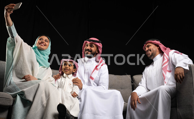 أجواء العيد في السعودية ، التقاط صور سيلفي لعائلة خليجية سعودية مبتسمة  تحتفل بالعيد  ، ارتداء اللباس السعودي التقليدي ، عيد الفطر المبارك ، عيد الأضحى ، زيارات العيد ، خلفية سوداء