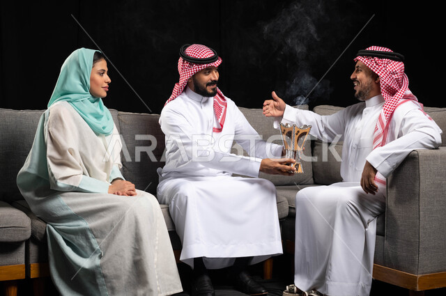 بورتريه لعائله عربيه سعوديه خليجيه في غرفة الجلوس, الاحتفال بالعيد السعيد, التطيب والتعطر بالعود والبخور في الأعياد والمناسبات, الزيارات العائليه والتجمعات الاسريه, ايماءات تدل على السعاده والفرحه بقدوم العيد, خلفيه سوداء
