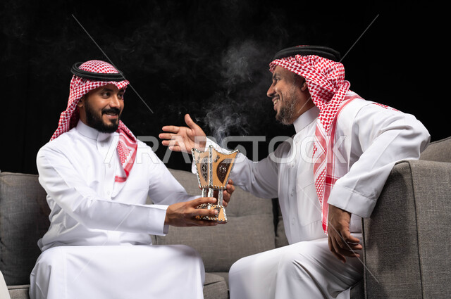 بورتريه لرجلان عربيان خليجيان سعوديان يرتديان الزي السعودي التقليدي ، حامل البخور ( المبخرة ) ، التطيب بالبخور والعود ، استخدام خشب العود في المناسبات والأعياد ، الفرح بقدوم العيد ، التجمعات الأسرية في العيد ، إيماءات تدل على الفرح ، خلفية سوداء