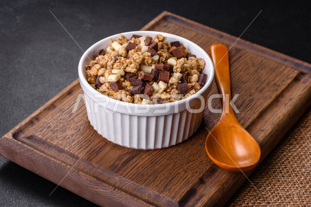 Close-up of a delicious healthy dish with cereal, granola and chocolate, healthy and delicious breakfast, diet, black background.