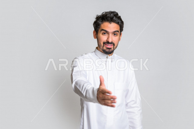 بورتريه لرجل عربي سعودي خليجي يرتدي الثوب السعودي , إيماءات يد تدل على المصافحه , التحيه والسلام, الموافقه والقبول, تعارف و صداقه, الشعور بالإيجابيه, الرضى والسرور , خلفية بيضاء .