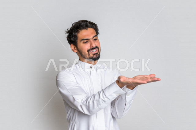 Portrait of a Saudi Arabian Gulf man in traditional dress, different facial gestures, hand gestures indicating carrying something, white background.
