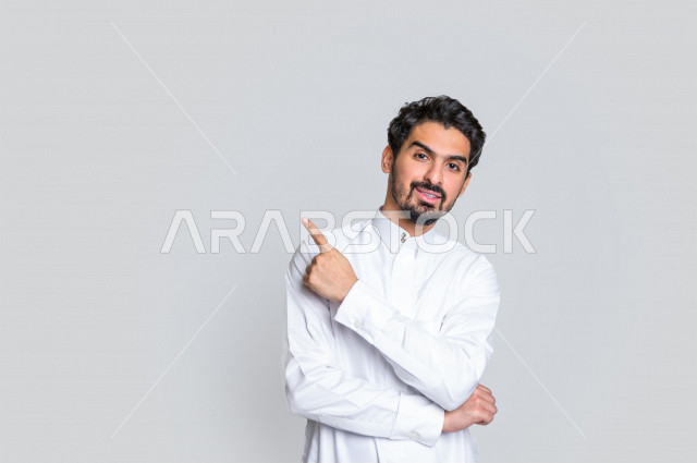 بورتريه لرجل عربي سعودي خليجي باللباس التقليدي , يؤشر بإصبعه لأعلى , إيماءات وجه مختلفة ، إشارات يدين مختلفة ، خلفية بيضاء .