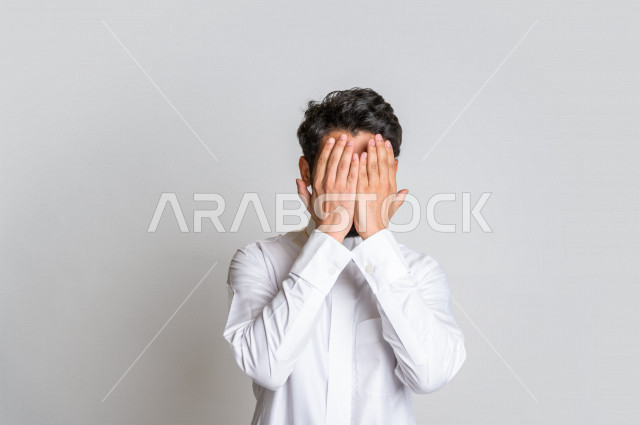 بورتريه لرجل عربي خليجي سعودي ، يرتدي الزي السعودي التقليدي ، يرفع يديه ويدعو الله بإيماءات وجه ويدين مختلفة تدل على التوسل والدعاء ، مفهوم الدعاء والحاجة ، العبادة والتقرب إلى الله ، خلفية بيضاء