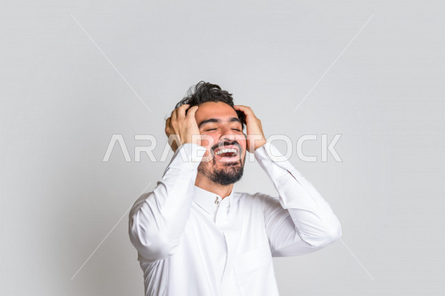 بورتريه لرجل عربي سعودي خليجي باللباس التقليدي , يقوم بإيماءات وجه تدل على الضحك بهستيريا ، إشارات يدين تدل على الفرحة والسعادة ، خلفية بيضاء .
