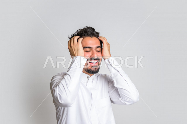 بورتريه لرجل عربي سعودي خليجي باللباس التقليدي , يقوم بإيماءات وجه تدل على الضحك بهستيريا ، إشارات يدين تدل على الفرحة والسعادة ، خلفية بيضاء .