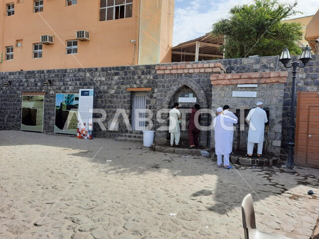 مجموعة من الرجال يستخدمون مياه بئر غرس في المدينة المنورة بالمملكة العربية السعودية، بئر مياه عذبة، بئر غرس التاريخي، معالم تاريخية اسلامية في السعودية