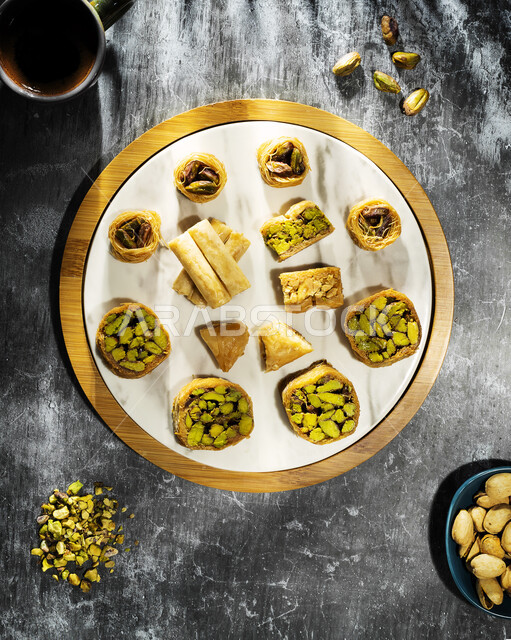 صورة مقربة لطبق البقلاوة اللذيذ حلا شرقي وحلويات رمضانية، قطع الحلوى الشهية، التحلاية وحلويات لذيذة، قطع البقلاوة خلفية بيضاء