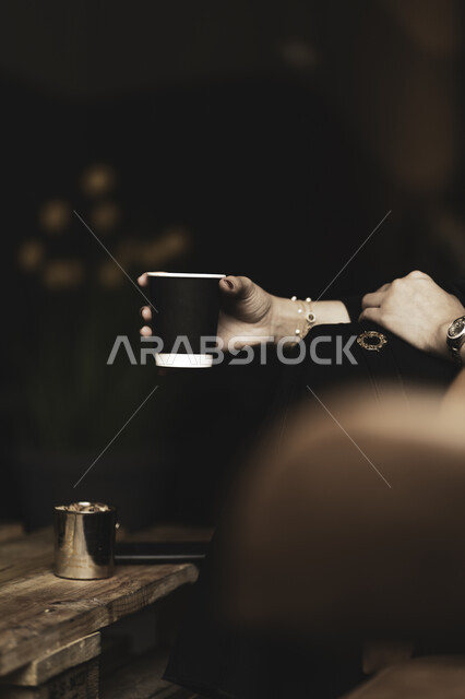 الإستمتاع بشرب القهوه في أجواء هادئه وقضاء وقت ممتع خارج المنزل ، تسليه وترفيه في مقاهي المملكه العربيه السعوديه ، طلب القهوه من متجر القهوه السعودي لإمرأه عربيه سعوديه تشرب القهوة