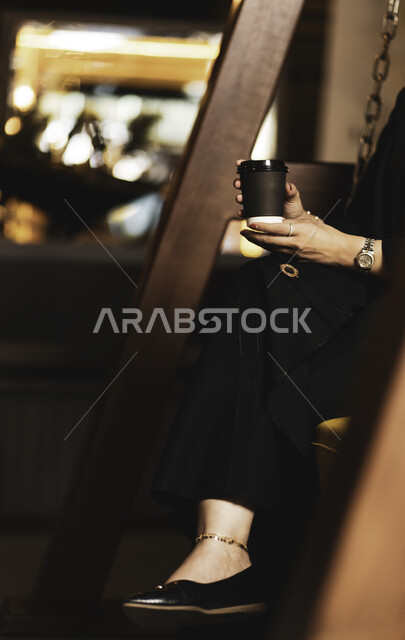 تسليه وترفيه في مقاهي المملكه العربيه السعوديه ، الإستمتاع بشرب القهوه في أجواء هادئه وقضاء وقت ممتع خارج المنزل ، طلب القهوه من متجر القهوه السعودي لإمرأه عربيه سعوديه تشرب القهوة