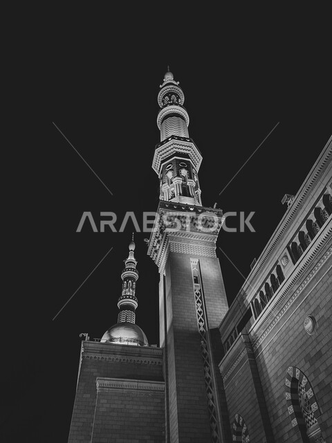 صورة من زاوية سفلية لمئذنة المسجد النبوي الشريف، مظلة الكترونية كبيرة، الحرم النبوي في المدينة المنورة بالمملكة العربية السعودية، معالم اسلامية مقدسة، صورة بالابيض والاسود