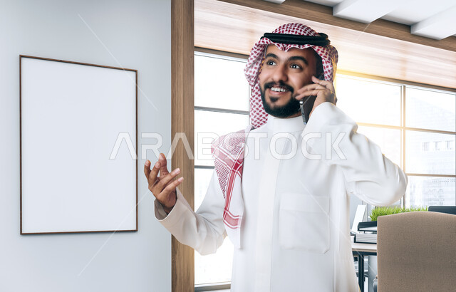 صورة مقربة لرجل عربي سعودي خليجي يستخدم الهاتف المحمول، إجراء مكالمة هاتفية، إدارة الأعمال ومتابعة العمل، عقد صفقات تجارية، العمل عن بعد، التسويق الإلكتروني، مكالمة خاصة بالعمل، اتصال وتواصل اجتماعي، اعمال مكتبية