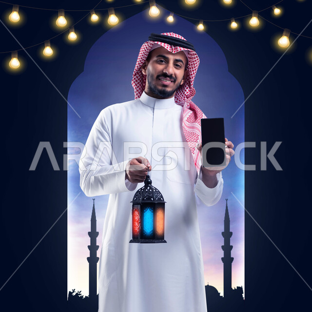 صورة مقربة لرجل سعودي خليجي عربي يمسك هاتف محمول بشاشة سوداء فارغة، فانوس شهر رمضان المبارك، عرض خدمات وتطبيقات الهاتف المحمول، التسوق الإلكتروني، استقبال شهر رمضان المبارك، إضاءة وزينة شهر رمضان، أجواء رمضانية، خلفية اسلامية زخرفية