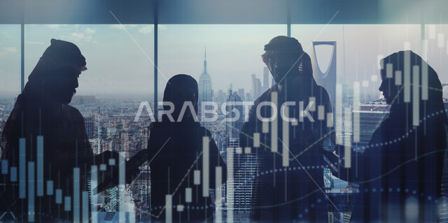 فريق عمل عربي خليجي سعودي داخل مقر الشركة مع خلفية مدموجة بابراج الرياض، رجل وامرأة يقفان بايدي متقاطعة، استخدام جهاز التابليت المحول، مراقبة المعلومات المالية، صعود وهبوط مؤشر البورصة، مراقبة الاقتصاد والمعلومات المالية، الرسم البياني للسوق المالي