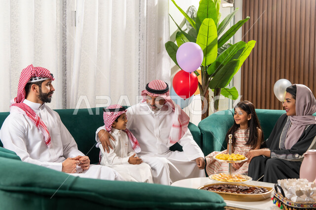 دردشة ومحادثات, عائلة عربية خليجية سعودية تحتفل في العيد السعيد, الاحتفال بقدوم العيد, ارتداء الثوب والشماغ السعودي,  الزيارات والتجمعات في العيد, بهجة وفرحة العيد, أجواء العيد في المجتمع العربي الخليجي السعودي, ايماءات تدل على الفرح والسعادة .