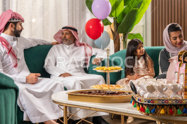 تبادل الاحاديث العائلية, عائلة عربية خليجية سعودية تحتفل في العيد السعيد, الاحتفال بقدوم العيد,  الزيارات والتجمعات في العيد, بهجة وفرحة العيد, أجواء العيد في المجتمع العربي الخليجي السعودي, ايماءات تدل على الفرح والسعادة .