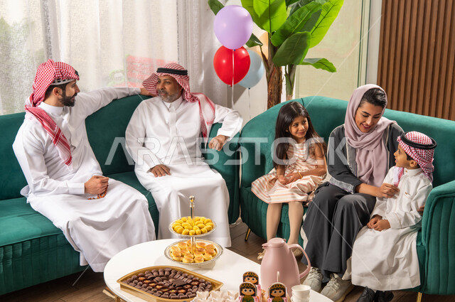 تبادل الاحاديث العائلية, عائلة عربية خليجية سعودية تحتفل في العيد السعيد, الاحتفال بقدوم العيد,  الزيارات والتجمعات في العيد, بهجة وفرحة العيد, أجواء العيد في المجتمع العربي الخليجي السعودي, ايماءات تدل على الفرح والسعادة .