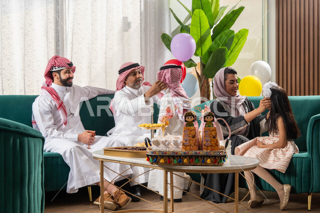 The joy and joy of the Happy Eid, an Arab Gulf family celebrates the Happy Eid, Eid gatherings and visits, gestures indicating joy, wearing the Saudi dress and shemagh, the Eid atmosphere in the Saudi Arab community, celebrating the advent of the Eid.